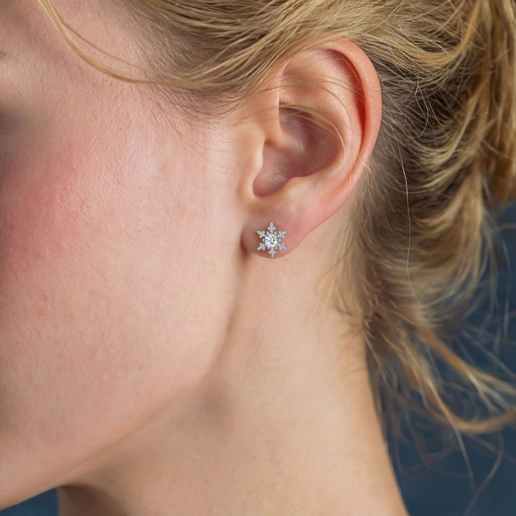 Anointed Garments Winter Spark Studs featuring a round moissanite stone in a platinum-plated snowflake setting on an ear