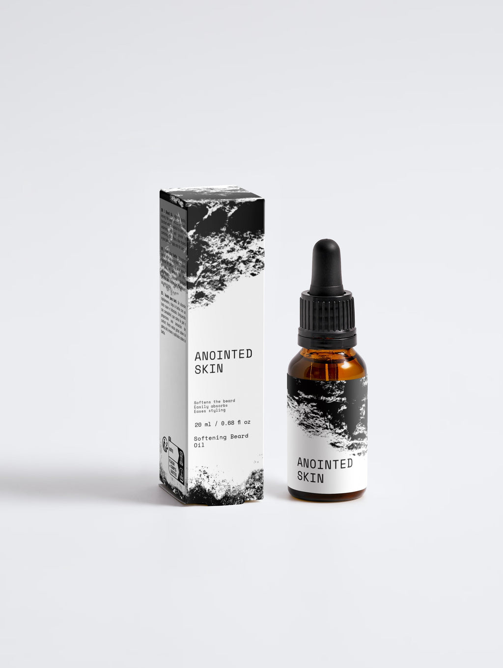 Anointed Garments Anointed Skin Softening Beard Oil in an amber glass dropper bottle next to its black and white box.