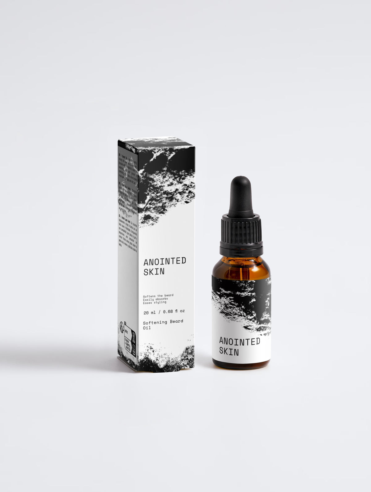 Anointed Garments Anointed Skin Softening Beard Oil in an amber glass dropper bottle next to its black and white box.