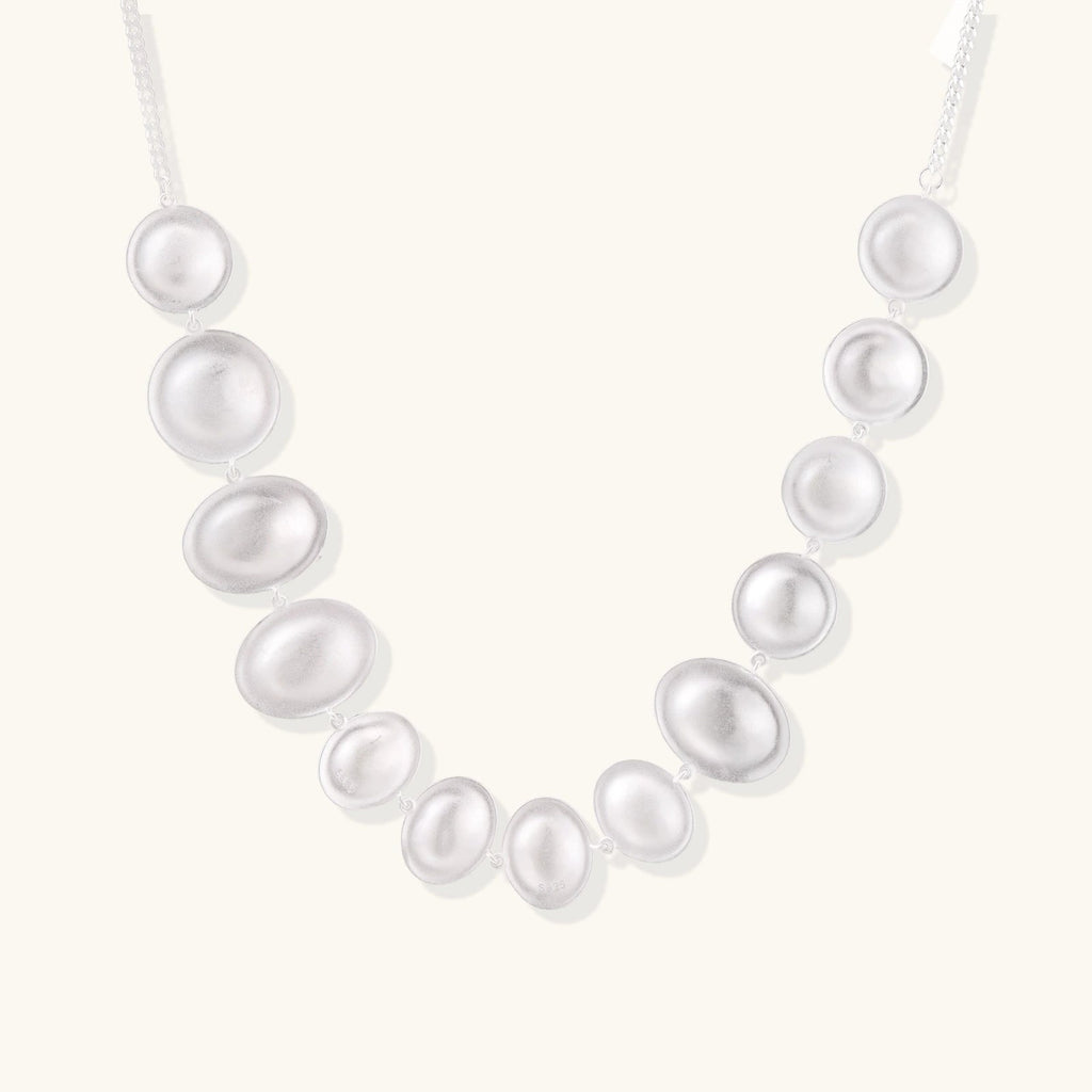 Anointed Garments Lunar Pearl Arc Necklace featuring graduated polished sterling silver circular forms on a chain.