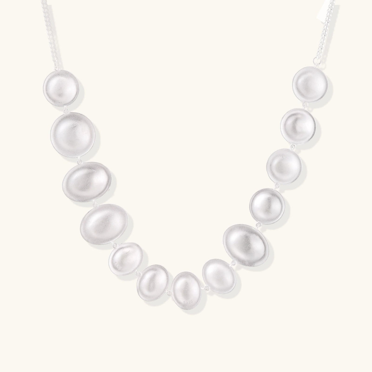 Anointed Garments Lunar Pearl Arc Necklace featuring graduated polished sterling silver circular forms on a chain.