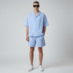 Anointed Garments model wearing a light blue and white striped button-down shirt and matching elastic waist shorts.