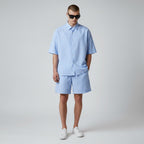 Anointed Garments light blue and white striped lounge shorts worn by a model with a matching short-sleeve shirt.