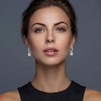Anointed Garments twisted infinity halo moissanite earrings in platinum-plated sterling silver worn by a woman.