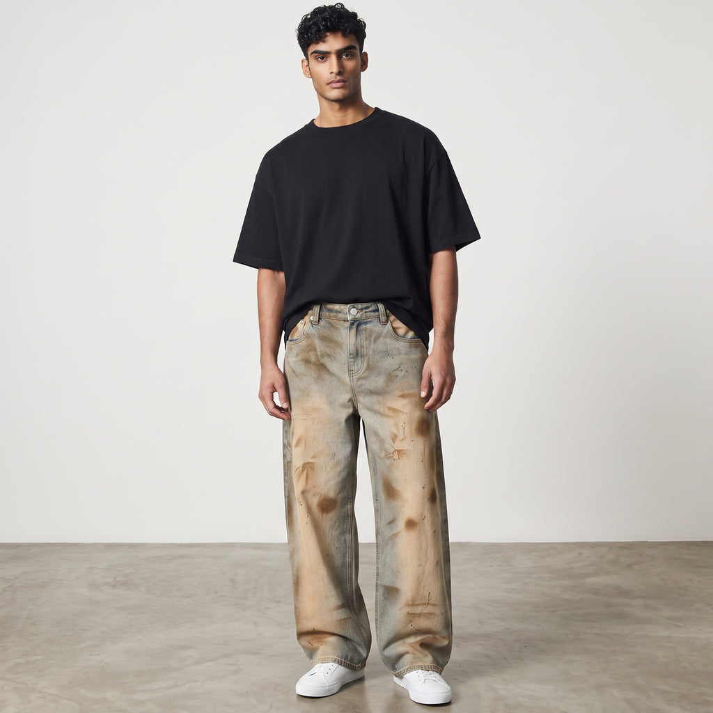 Model wearing Anointed Garments relaxed fit barrel-leg denim jeans with a vintage wash and distressed detailing.