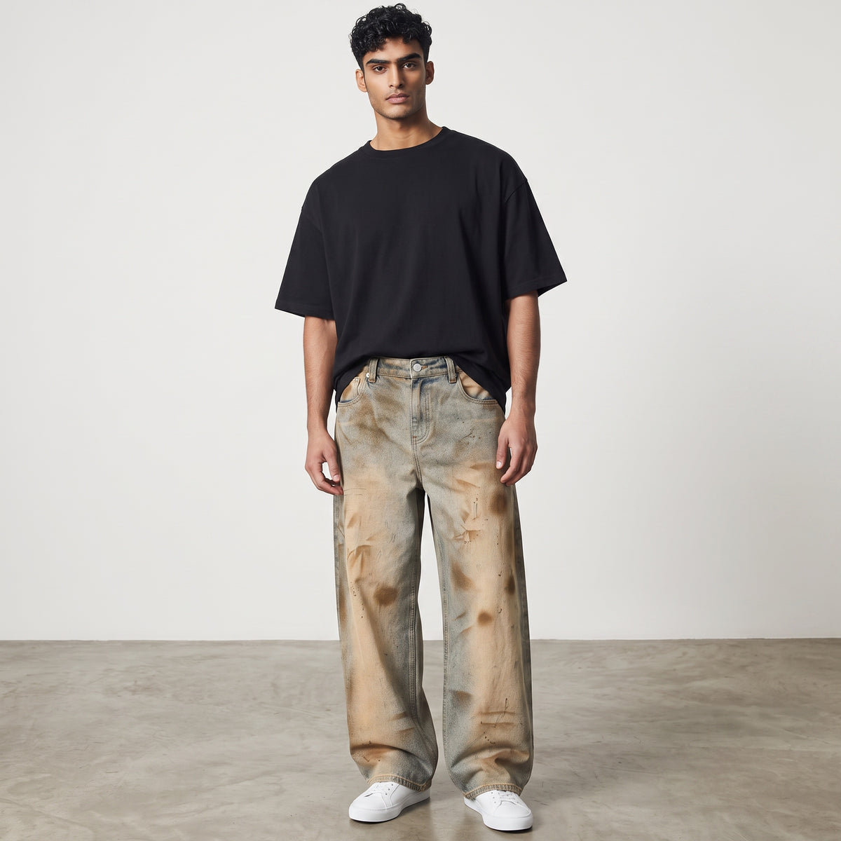 Model wearing Anointed Garments relaxed fit barrel-leg denim jeans with a vintage wash and distressed detailing.