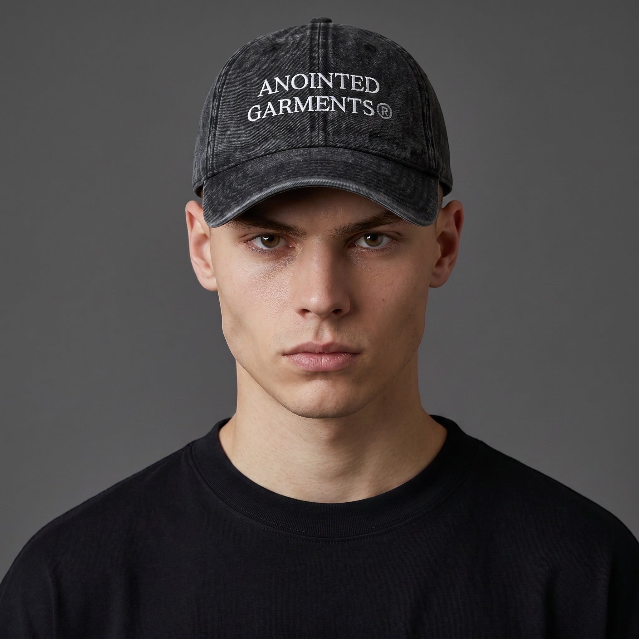 A man wearing a black vintage-wash cotton Anointed Garments baseball cap with white embroidered logo text.