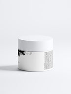 Anointed Garments Volcanic Sand Face & Body Scrub in a white jar with black text on a clean white background.
