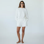 Woman wearing Anointed Garments white fleece lounge shorts and matching sweatshirt with an elasticated drawstring waist