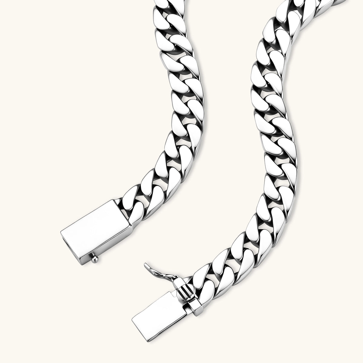 Polished 925 sterling silver Cuban link chain necklace, 550mm length, shown flat and draped on cream background.